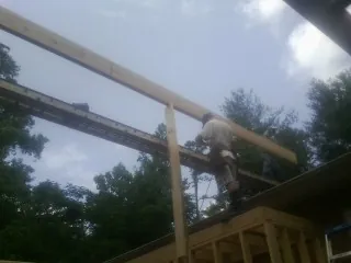 Carpenter setting a ridge beam over a new addition frame — Ice Dam Removal by Roofing Brothers in Wanatah