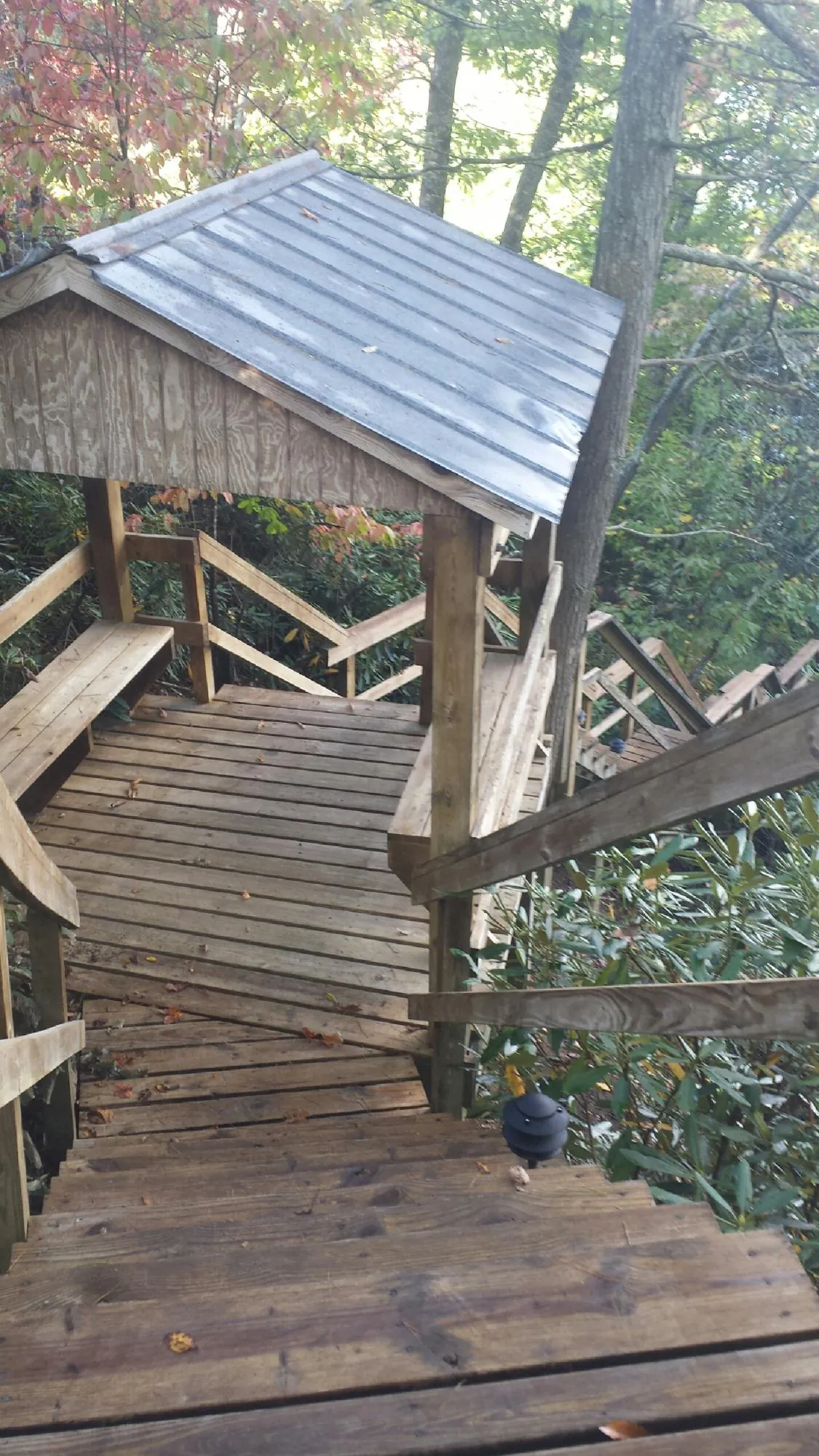 Metal roofed shelter over wooden steps on a wooded walkway — Skylight Repair & Installation work by our crew in Wanatah
