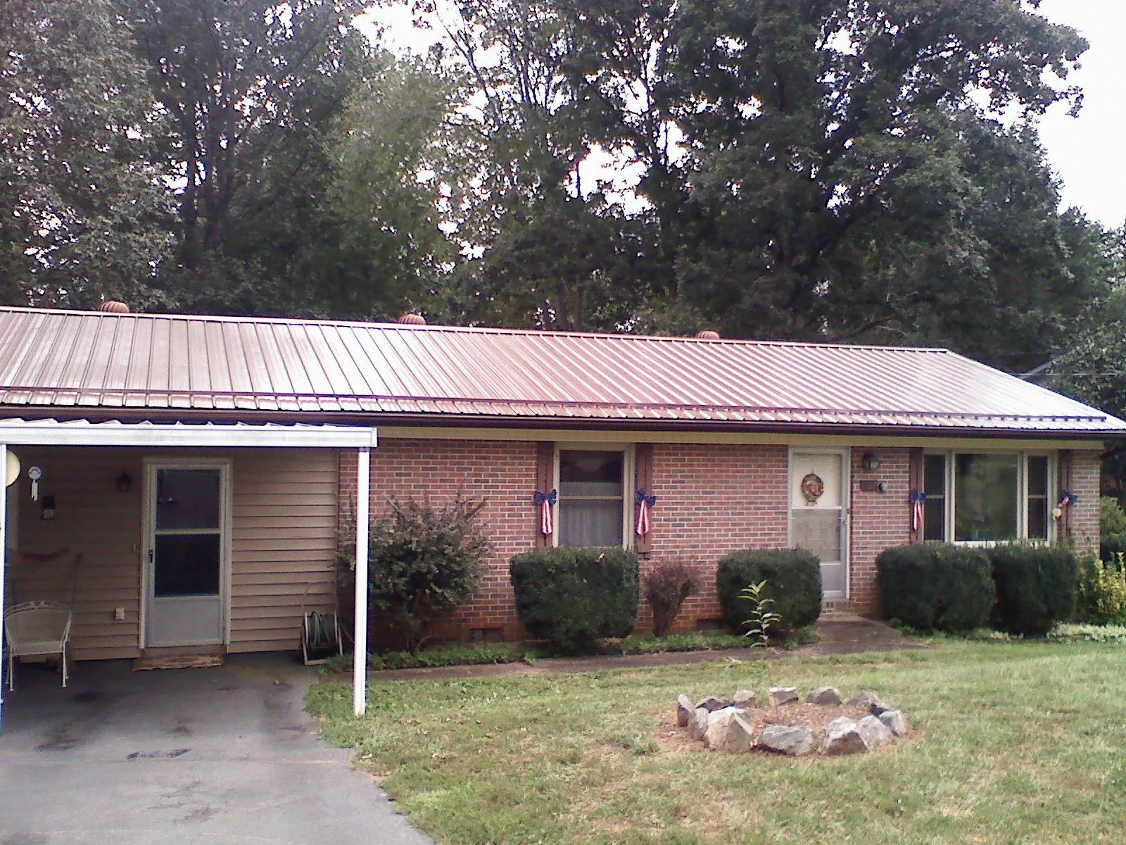 Bronze metal roof and carport on a brick ranch home — Roof Repair work by our crew in Wanatah